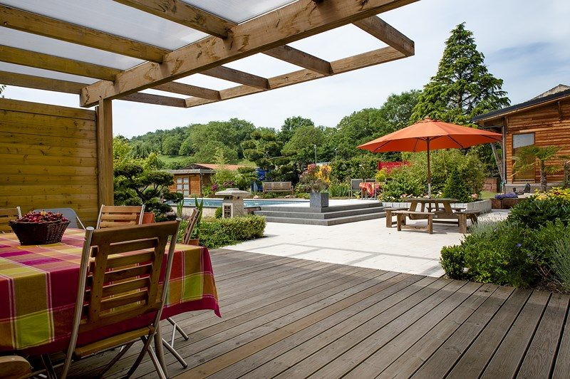 Pergola en bois au-dessus d'une terrasse, avec vue sur le jardin